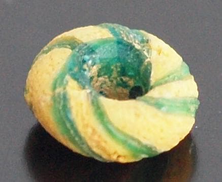 クリアな青緑に鮮やか黄で、回転する輪状モチーフを描くモザイク平玉　前後～6C頃の