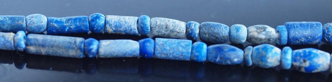 古代濃紺ラピスの管玉や丸玉をほぼ左右対称に編み、トップに斧型や多面体、80個の連